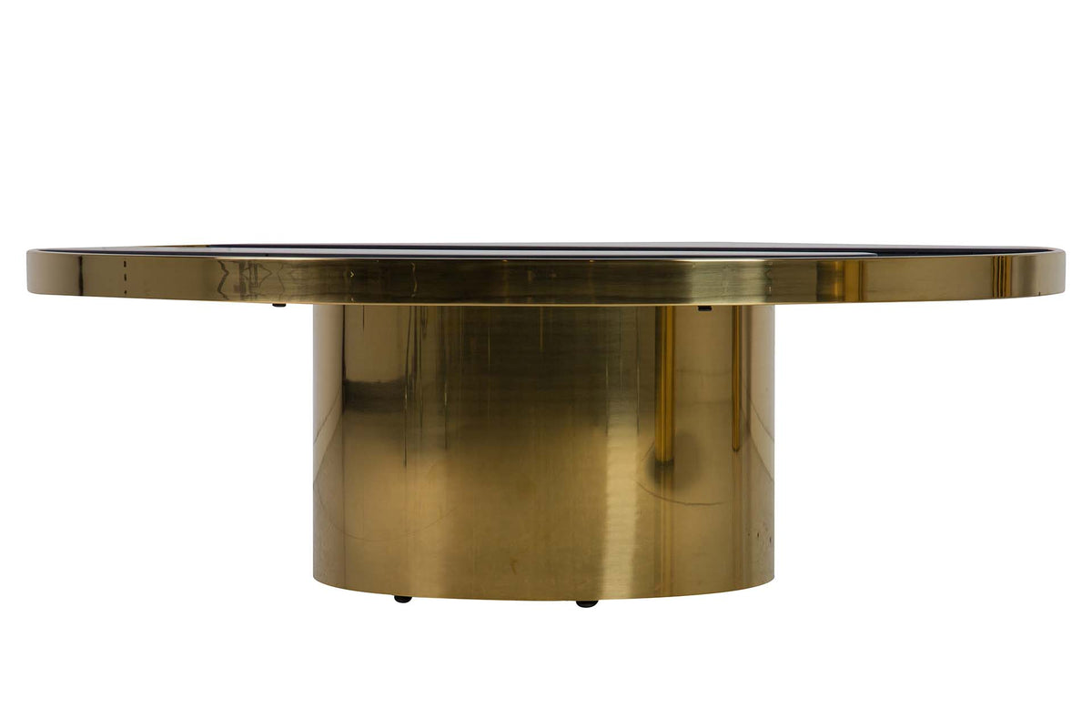 A modern round coffee table featuring a brushed brass cylindrical pedestal base and a matching round brass top with a dark inlay | KULORI Malta & Gozo