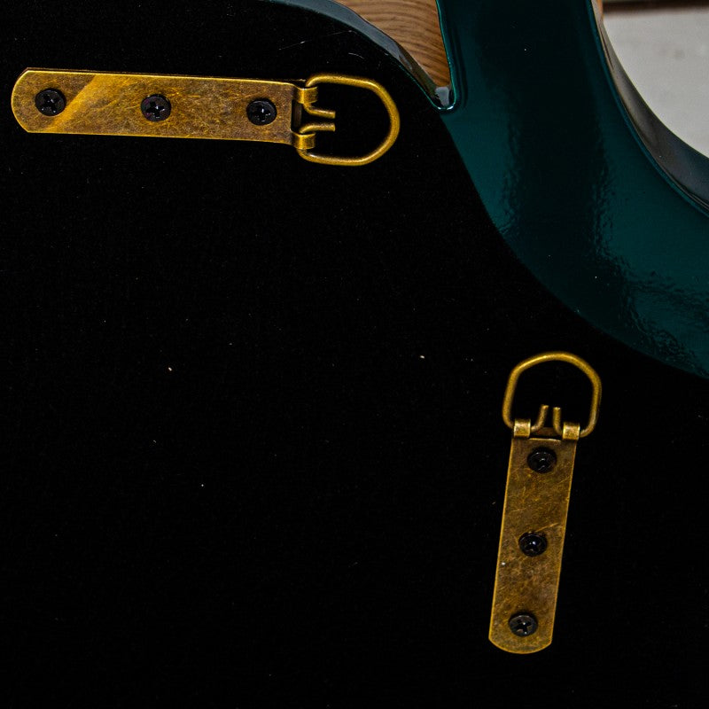 Close-up of a teal and black electric guitar body showing two brass hardware pieces, likely tailpiece and bridge plate components | KULORI Malta & Gozo