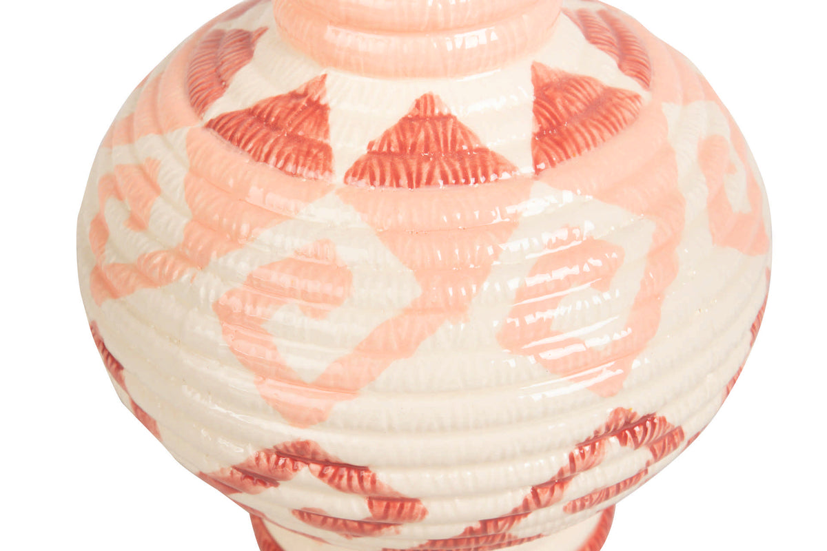 A close-up of a glossy ceramic vase with a ribbed texture, featuring a pattern of coral pink and white geometric shapes on a white background | KULORI Malta & Gozo