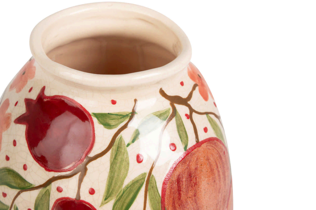 Close-up of a ceramic vase with a cream-colored glaze, decorated with painted red pomegranates, green leaves, and brown branches | KULORI Malta & Gozo