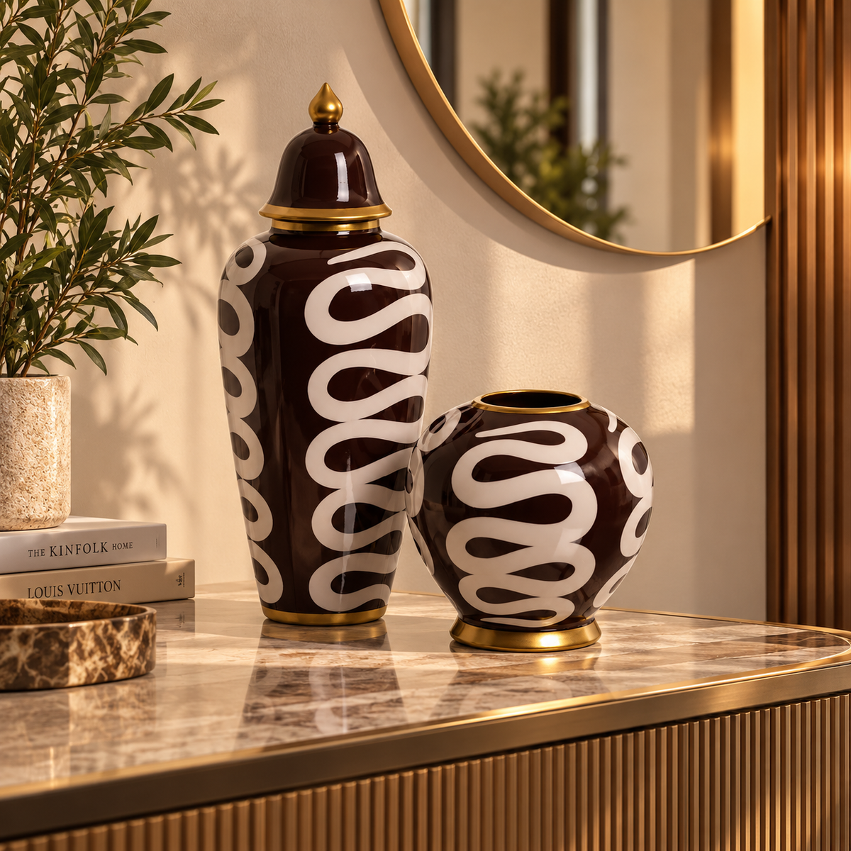 Two decorative ceramic vases with a glossy dark brown and white wavy pattern and gold trim, displayed on a marble console table in a styled interior setting | KULORI Malta & Gozo