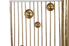 Close-up of a gold-toned metal chair or stool with vertical slats and three round metallic finials | KULORI Malta & Gozo