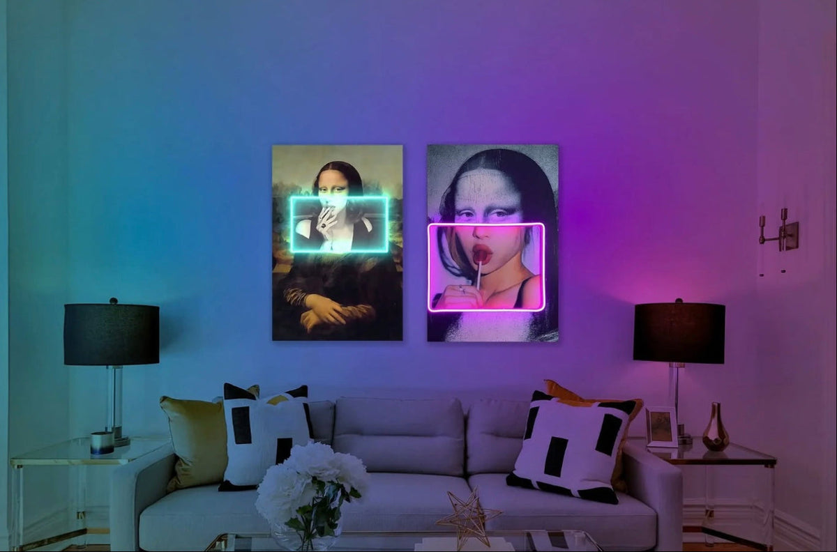 Two vertical wall art prints displayed above a sofa in a modern living room. The left print shows a dark portrait with a glowing cyan rectangular frame, and the right print shows a dark portrait with a glowing pink rectangular frame.