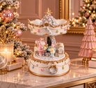 A decorative two-tiered Christmas carousel music box with gold trim and pastel-colored figurines, displayed on a marble console table in a festive holiday room setting.