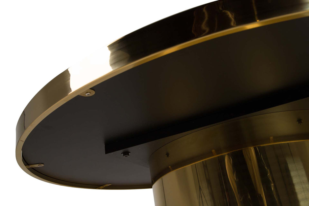 Close-up of a round table base with a brushed gold metal finish and a black circular top surface | KULORI Malta & Gozo