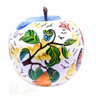 A decorative apple-shaped object with a white base and hand-painted multicolour designs, including green leaves | KULORI Malta & Gozo
