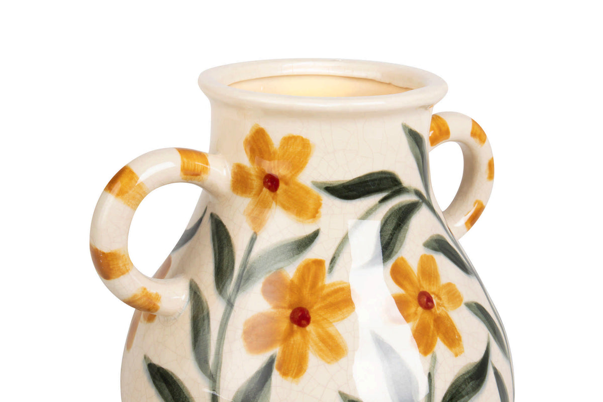 A cream-colored ceramic vase with two loop handles, decorated with hand-painted yellow flowers and green leaves.