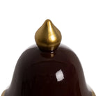Close-up of a dark brown ceramic object with a gold spike | KULORI Malta & Gozo