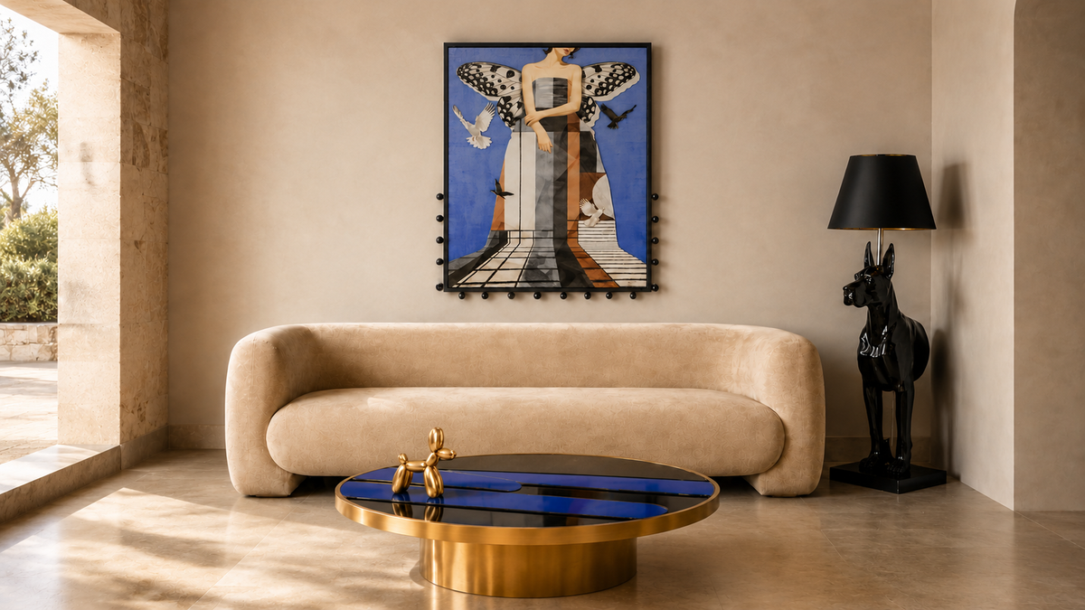 A framed art print featuring a stylized figure under a butterfly, displayed on a beige wall above a curved cream sofa in a modern, sunlit living room.