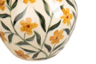 Close-up of a glossy ceramic vase with a hand-painted floral pattern featuring yellow flowers and green leaves.