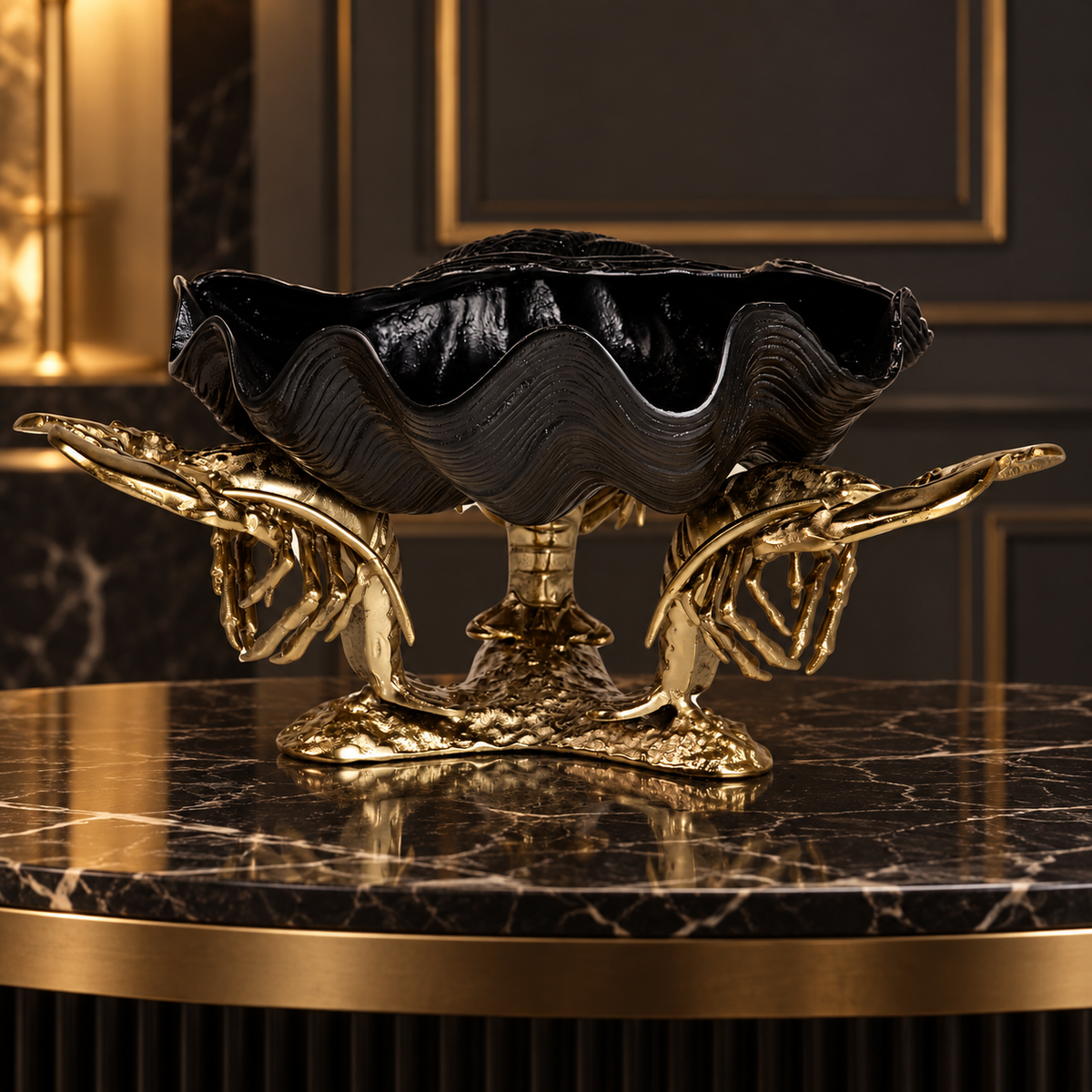 A decorative pedestal bowl with a black clam-shell style top and ornate gold claw-like supports, displayed on a dark marble table in an elegant interior setting | KULORI