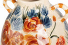 Close-up of a ceramic vase with a cream-colored glaze, decorated with hand-painted orange flowers, blue flowers, and green stems.