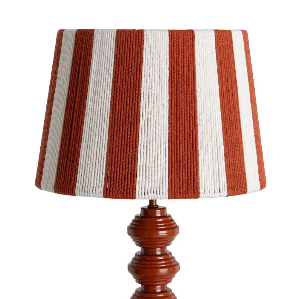 A table lamp with a pleated fabric shade featuring alternating rust red and off-white vertical stripes, mounted on a polished reddish-brown metal base | KULORI